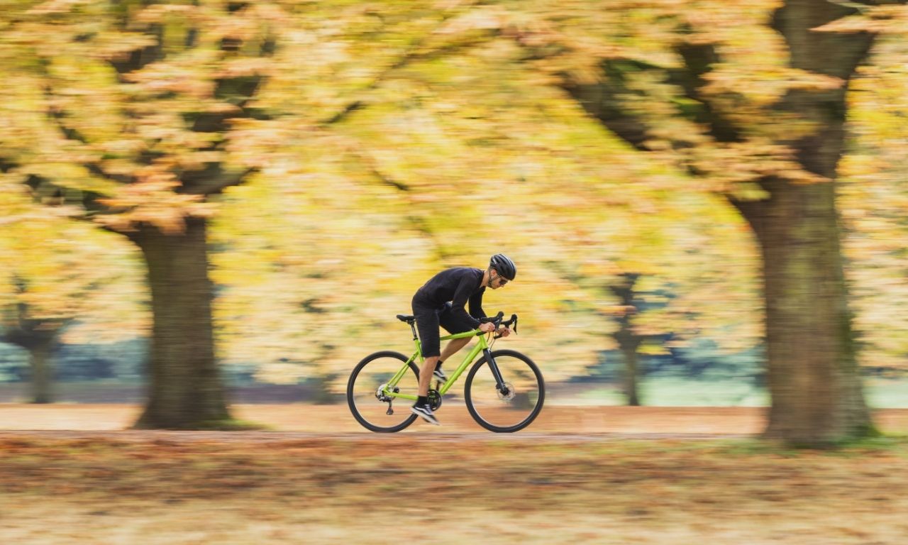 Mann fährt mit Rennrad von AT Cyles durch den Wald