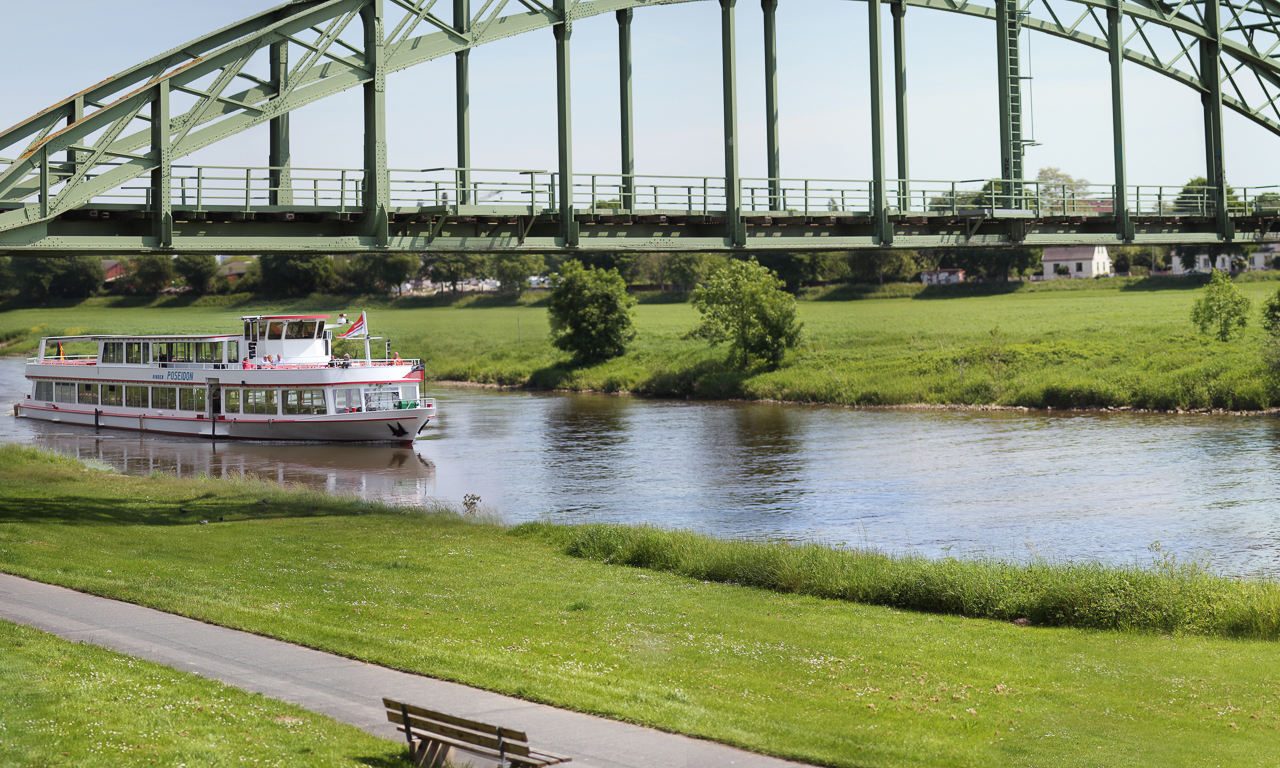 Schiff der Mindener Fahrgastschiffahrt auf dem Wasser / Brücke im Hintergrund